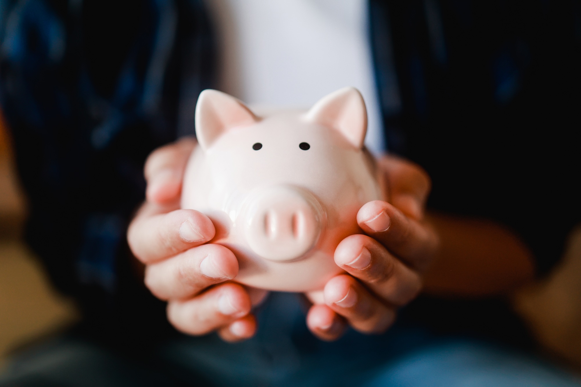Hands holding piggy for saving money. Invest and finacial bank concept